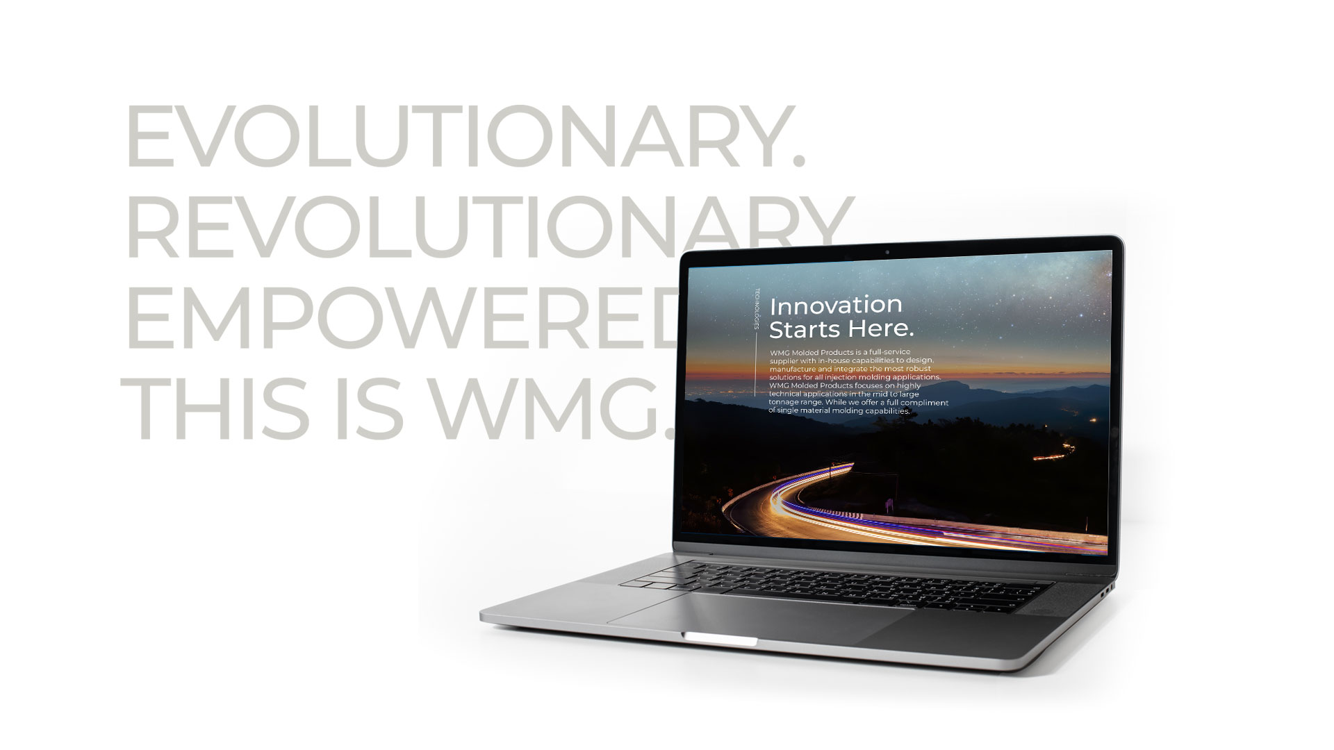 Laptop displaying text about innovation with a background image of a road at night. Bold words on the side read: "Evolutionary. Revolutionary. Empowered. This is WMG.