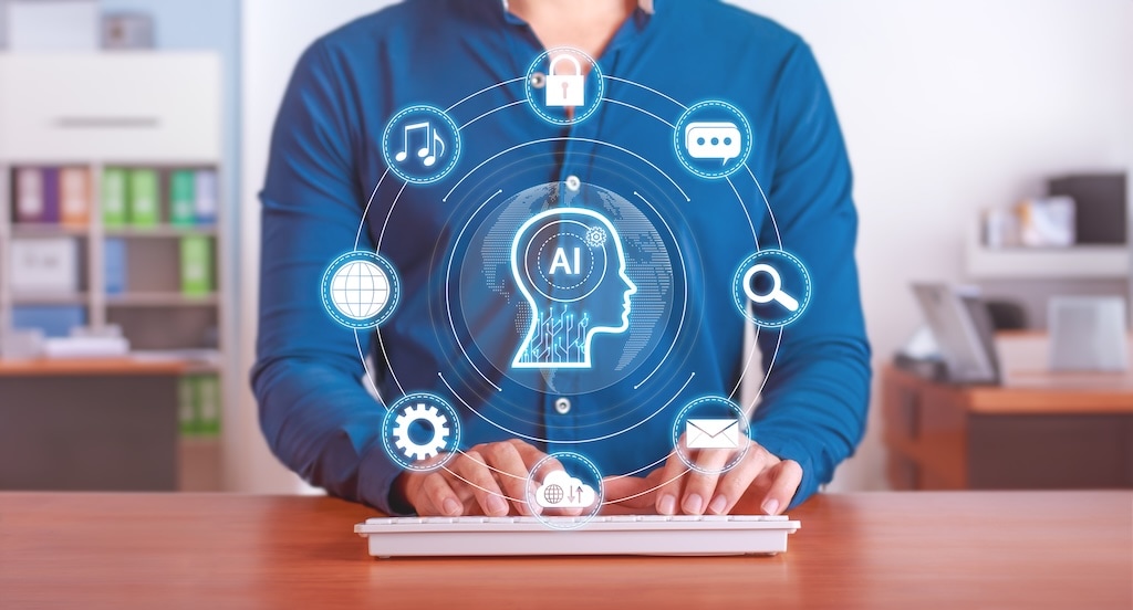 Person typing on a keyboard with a digital interface displaying an AI icon and various technology and communication symbols around it.