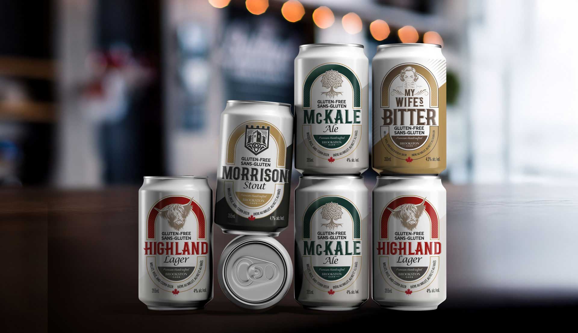 A selection of seven gluten-free beer cans in various styles, including lager, ale, stout, and bitter, displayed on a dark surface with a blurred background.