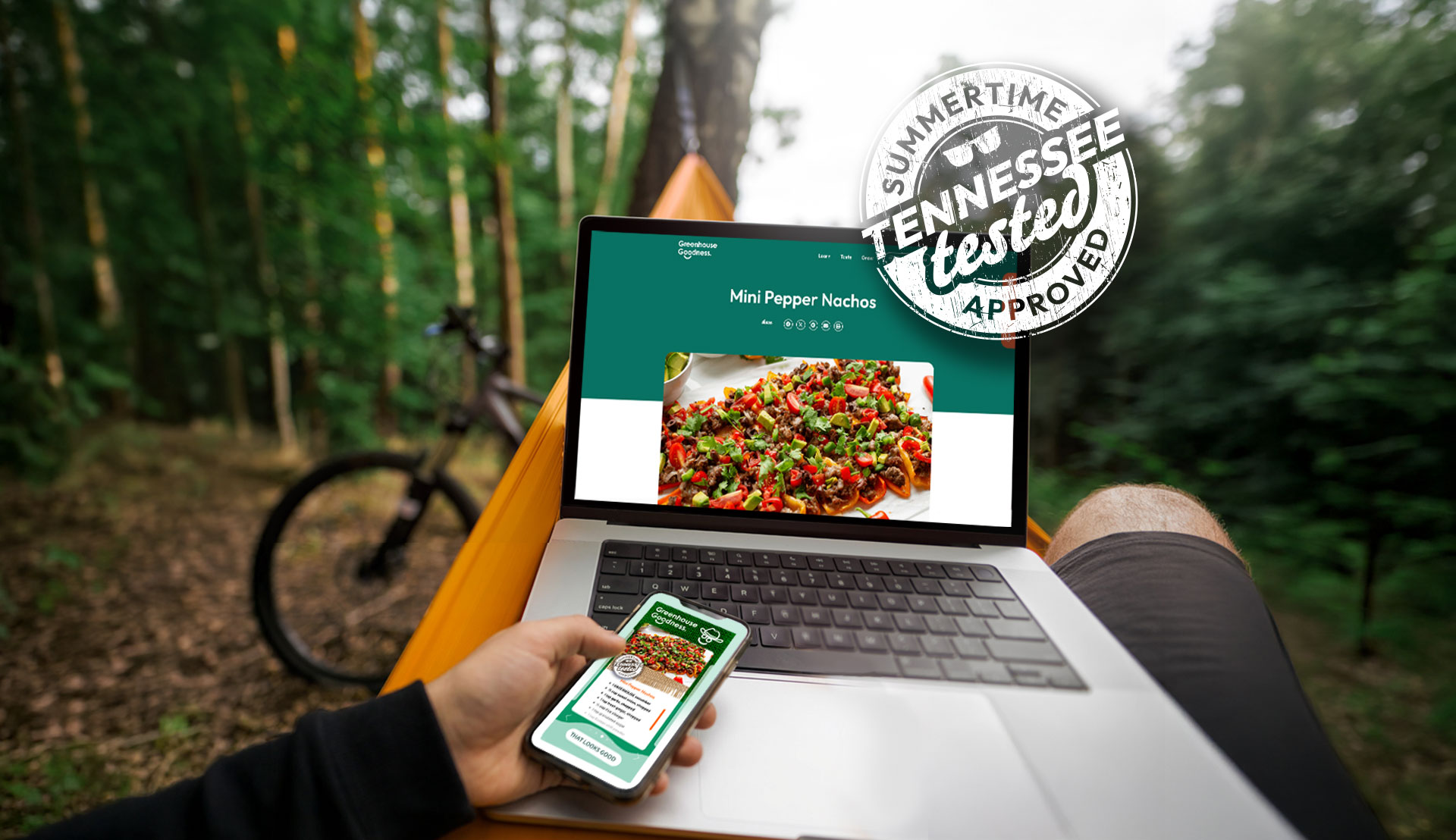 Person in a hammock outdoors using a laptop and smartphone to view a recipe for mini pepper nachos, with a bicycle and trees in the background. "Tennessee Tested Approved" graphic overlaid.